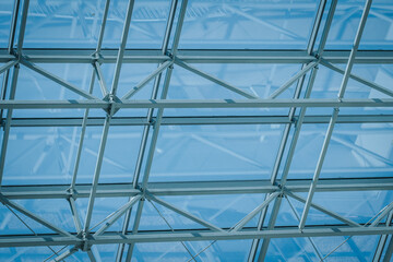 Fototapeta premium Glass ceiling structure with metal framework allowing natural light to filter through, creating a bright and airy atmosphere in a modern architectural setting
