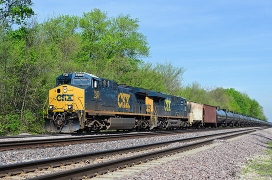 A pair of CSX Transportation locomotives lead a westbound empty ethanol unit train up a grade on Union Pacific Railroad tracks as it passes  through northeastern Illinois.