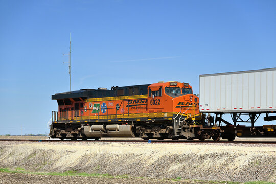 A single locomotive, serving as a rear-train distributed power unit (DPU), helps move a Burlington Northern Santa Fe stack train along a rural stretch of right-of-way.