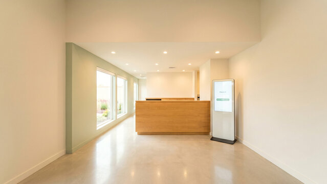 Minimalist clinic reception lobby with wooden counter check in kiosk and large window perfect for medical branding healthcare mockup and clinic advertising
