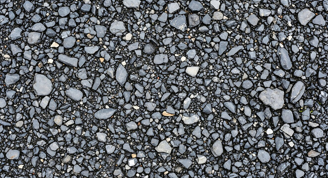 Macro topdown view of dark grey crushed stones and gravel texture featuring a detailed granular surface ideal for construction industrial design and road backgrounds
