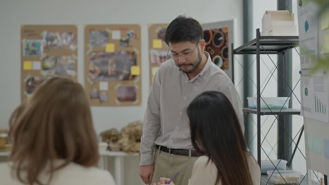 Workshop presentation creative team discussion art studio with designer speaking to colleagues office meeting man team presentation planning discussion workplace whiteboard colleague project male
