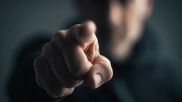 Close up of mans fist pointing finger straight toward the viewer