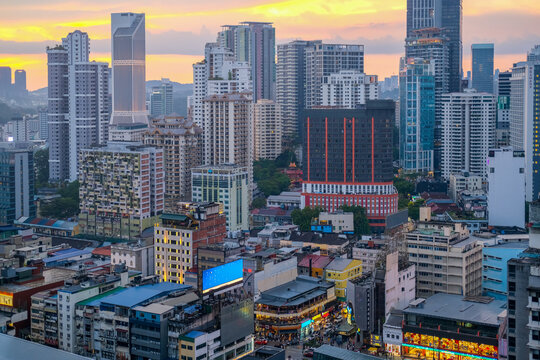 Bukit Bintang cityscape at dusk in Kuala Lumpur, showing dense urban buildings, glowing lights, and a vibrant commercial district popular with local and international tourists.