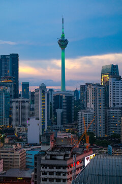 Bukit Bintang cityscape in Kuala Lumpur featuring the majestic Kuala Lumpur Tower surrounded by dense modern buildings, capturing vibrant urban atmosphere during evening hours.