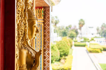 Fototapeta premium High relief guardian figure temple door Prasat Thong Kham Kanchanaphisek golden palace Wat Chantharam, ThaSung UthaiThani Thailand gilded ornament mirrored mosaic.