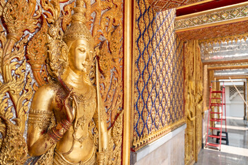 Fototapeta premium High relief guardian figure temple door Prasat Thong Kham Kanchanaphisek golden palace Wat Chantharam, ThaSung UthaiThani Thailand gilded ornament mirrored mosaic.