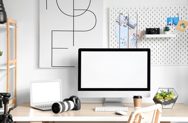 Fototapeta premium Photographer's workplace with computer monitor and laptop in light office
