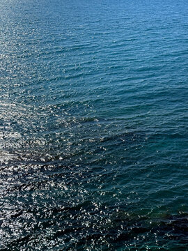 Ocean blue glittering calm water vertical.