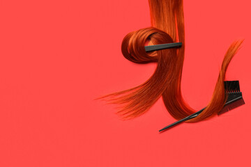 Fototapeta premium Ginger hair strand with clip and brush on red background