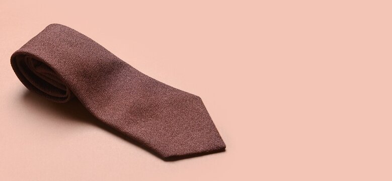 Stylish necktie on beige background with space for text
