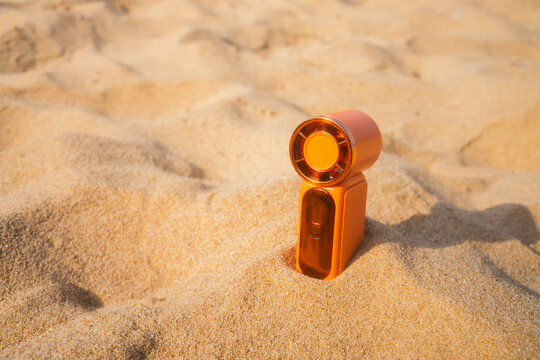 Portable handy fan on the beach and the background is the sea and the sky in summer.