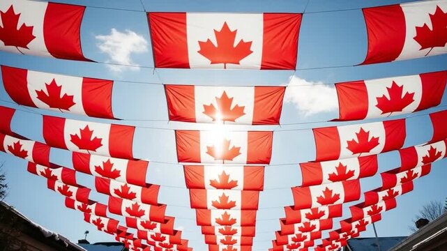 Rows of Canadian flags hanging overhead against a bright blue sky for national celebration and patriotic display