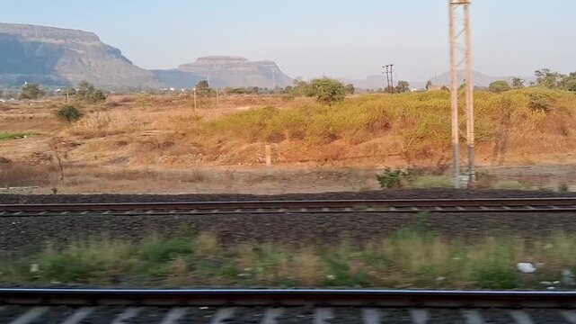 A peaceful train journey through the beautiful countryside with stunning mountain views and endless railway tracks.