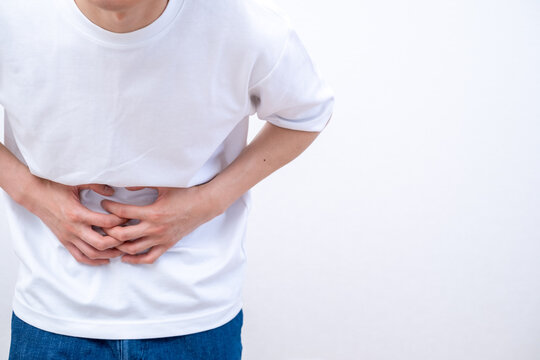 腹痛でお腹を押さえる男性