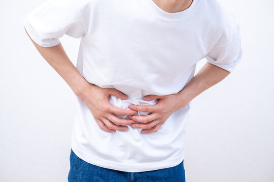 腹痛でお腹を押さえる男性
