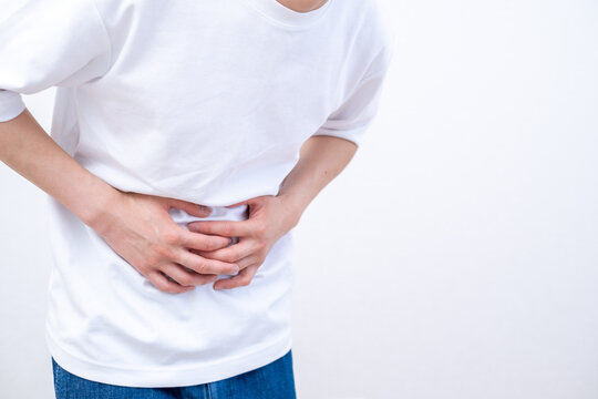 腹痛でお腹を押さえる男性
