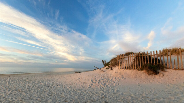 Scenic sand dunes with wooden fence on the Praia de Mira Miravella Beach Dunes at twilight sunset in Portugal PRT