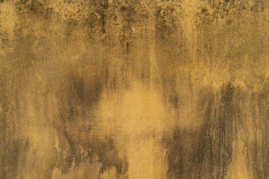 old yellow cement rupture moldy wall or top view table ancient golden paint to dirty stain black concrete and peeling surface for texture floor background retro backdrop construction to dark wallpaper