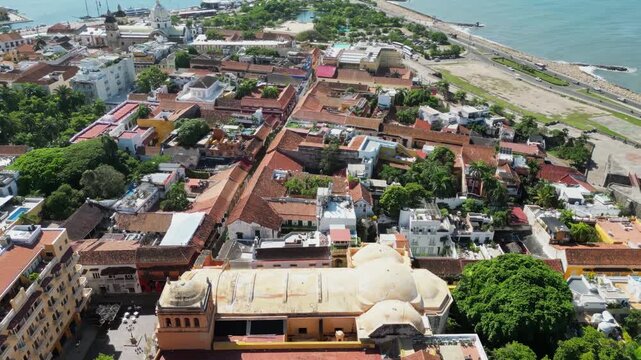 Aerial view over historic walled district of Cartagena Colombia featuring colonial architecture and modern skyline along Caribbean coast.
