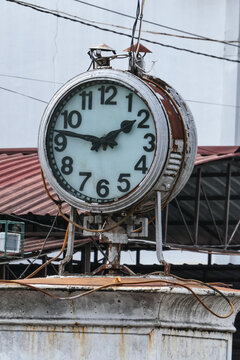 Vintage outdoor street clock mounted on stone pedestal in Yogyakarta, Indonesia