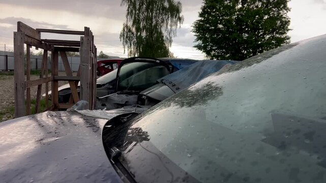 Electric car junkyard. Car beyond repair after accident. Car rusting in junkyard. Scrap metal being recycled. Dismantling of spare parts, scrap metal recycling.