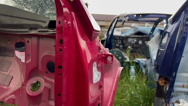 Electric car junkyard. Car beyond repair after accident. Car rusting in junkyard. Scrap metal being recycled. Dismantling of spare parts, scrap metal recycling.