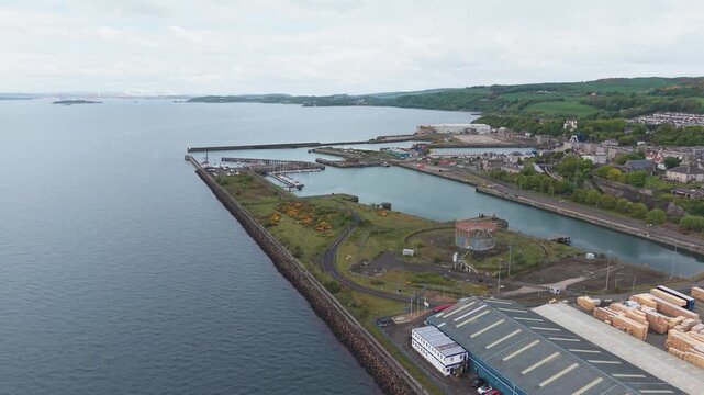 Aerial cinematic drone forward flyover shot of Burntisland docks, historic industrial harbour, and shipping port, Fife, Scotland
