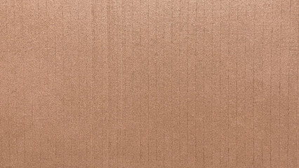 Fototapeta premium Close-up brown kraft cardboard with fine grain and layered texture. Light and shadow highlight the rhythmic ridge structure. Great for sustainable or handcrafted visual themes.