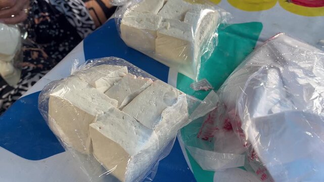 Fresh raw white tofu blocks packaged in clear plastic bags