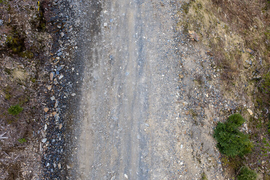 Aerial View of Rugged Gravel Road and Rocky Trail Through Forested Hills in BC Canada