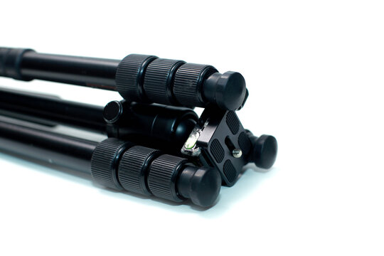 close-up, low-angle perspective of the tripod head mechanism, highlighting the quick-release mounting plate with rubber padding