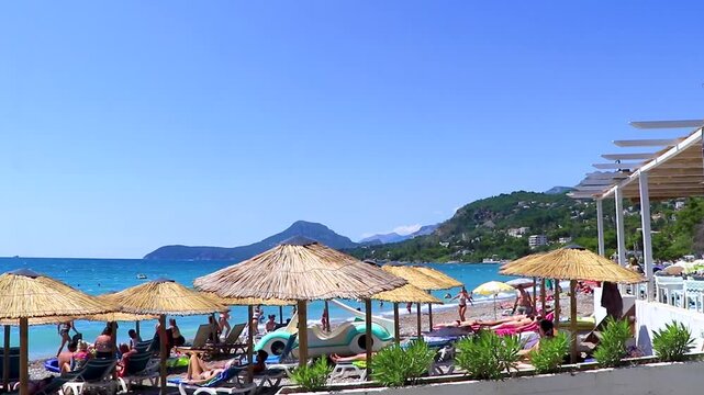 Bar Montenegro Beach tourists people water waves sun loungers parasols.