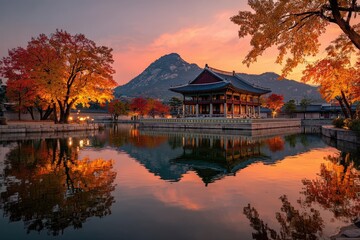 Fototapeta premium Traditional Korean pavilion reflected in a tranquil pond surrounded by vibrant autumn foliage and mountains under a colorful sunset sky in South Korea
