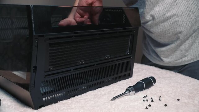 Installing liquid cooling radiator into computer case, careful positioning and mounting of the radiator inside the case during personal computer assembly