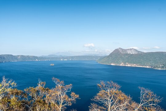 Serene blue waters of Lake Mashu under a clear autumn sky in Hokkaido.