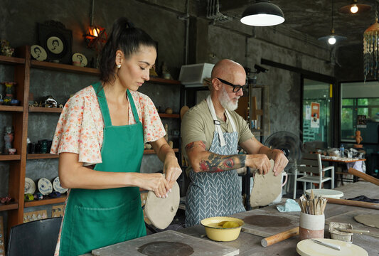 A happy couple makes ceramic plates in a workshop