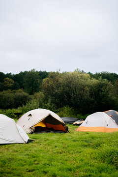 Multiple Camping Tents On Green Grass Field