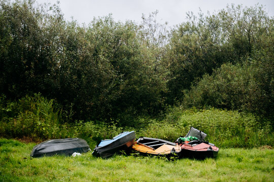 Colorful Kayaks Lying On Green Grass