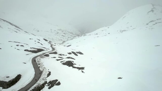 Aerial drone side move shot showing the Shingo La Pass road amid snow covered Himalaya mountains during snow fall showing the cold and beautiful environments of Ladakh, Leh, Sissu and Himachal Pradesh