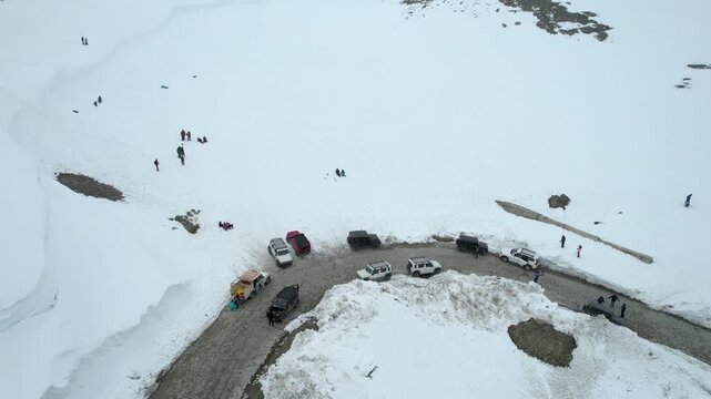 Aerial drone shot following the winding Shingo La pass road surrounded by snow covered fields among the Himalaya mountains showing the transport infrastructure in Ladakh Leh Sissu India