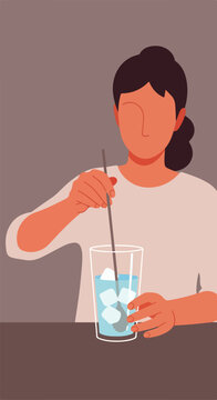 Faceless person stirring a tall glass of ice water with a spoon on a brown table