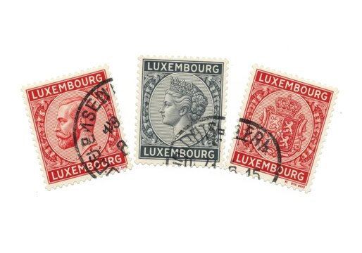 Three vintage postage stamps from luxembourg featuring portraits and a coat of arms, isolated on white background