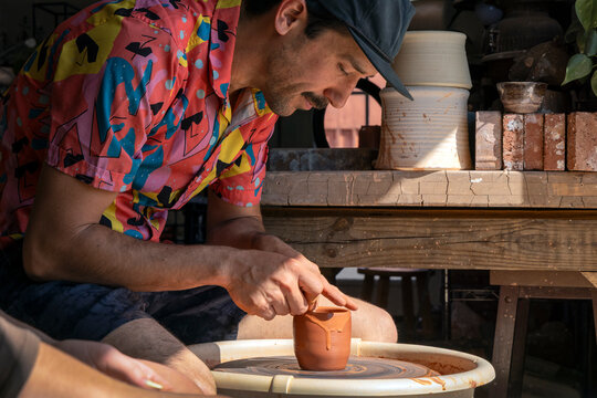 Man focused on clay spinning on wheel