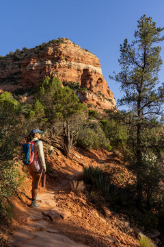 Lone woman hiker on narrow rugged high desert trail vertical