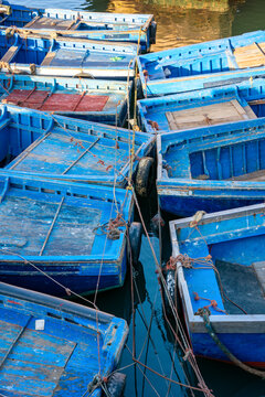 Empty blue fishing boats tightly moored in harbor