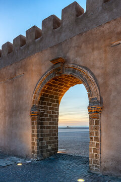 Historic stone archway with sea at dusk in Essaouira, Morocco