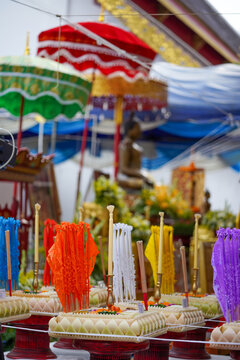 Traditional Northern Thai Lanna cultural festival with dancers performing Fon Lep (fingernail dance), religious Buddhist merit-making ceremony, candles, marigold flowers, and white holy thread.