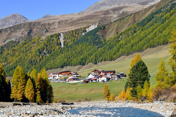 Blick über den steinigen Karlinbach auf den Weiler Melag im herbstlichen Langtauferer Tal, Südtirol © Ilhan Balta