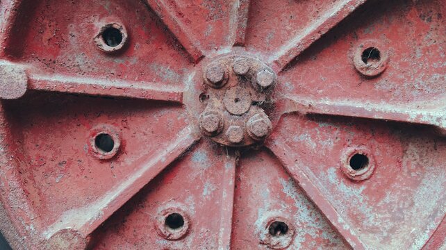 Close-up of Rusty Red Vintage Tractor Wheel Hub. Metal Texture